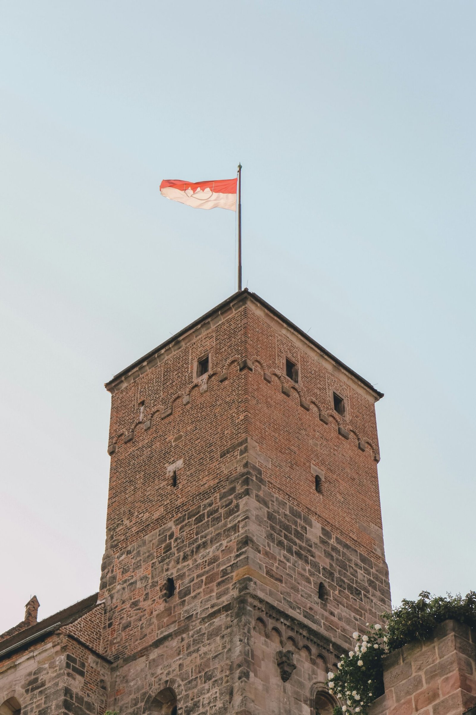 a tall brick building with a flag on top of it