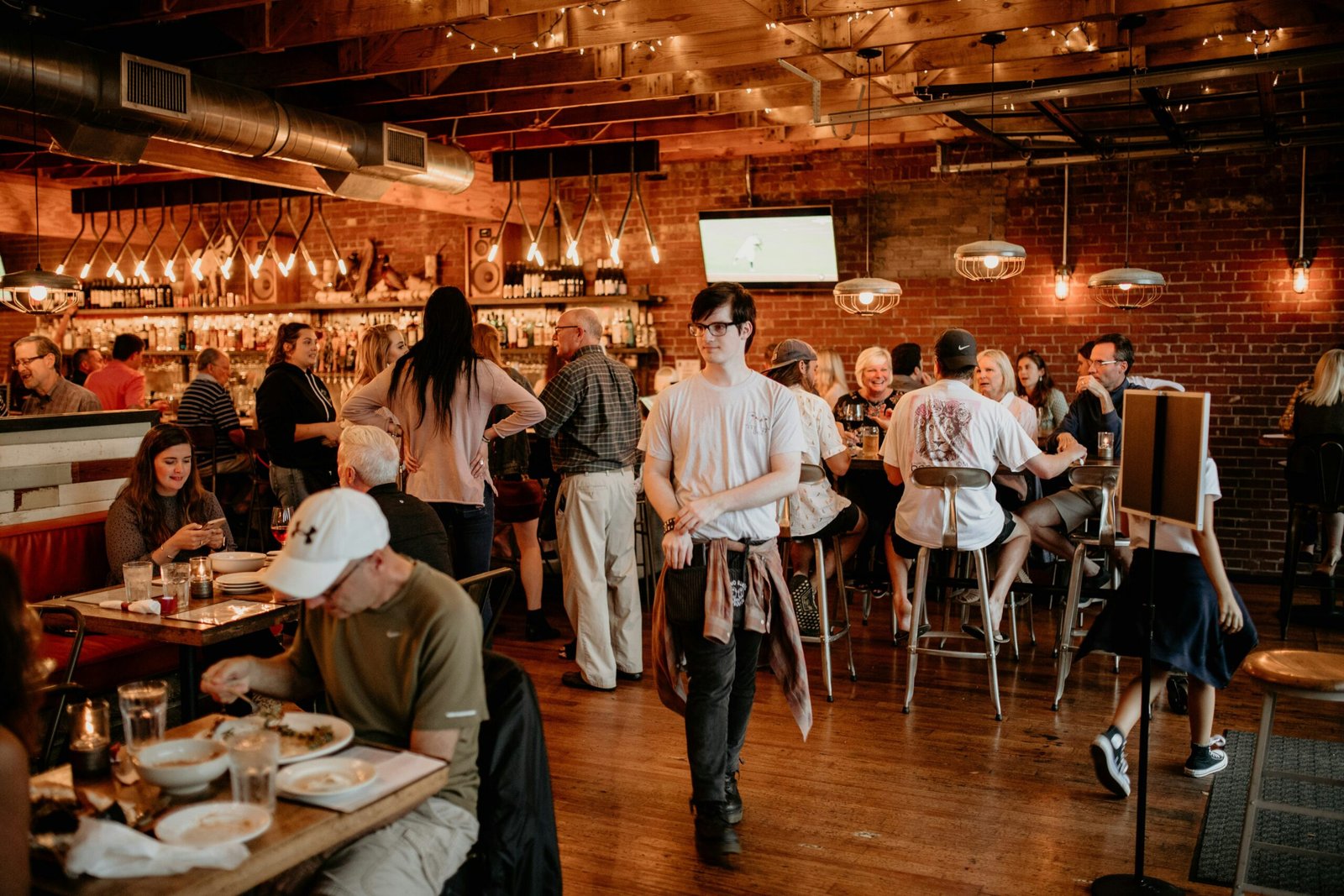 a group of people sitting at tables in a restaurant