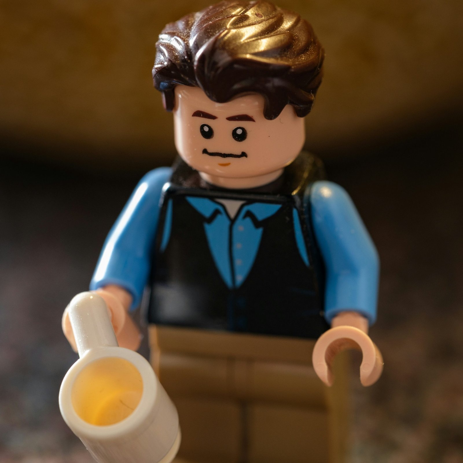 a lego man holding a cup of coffee