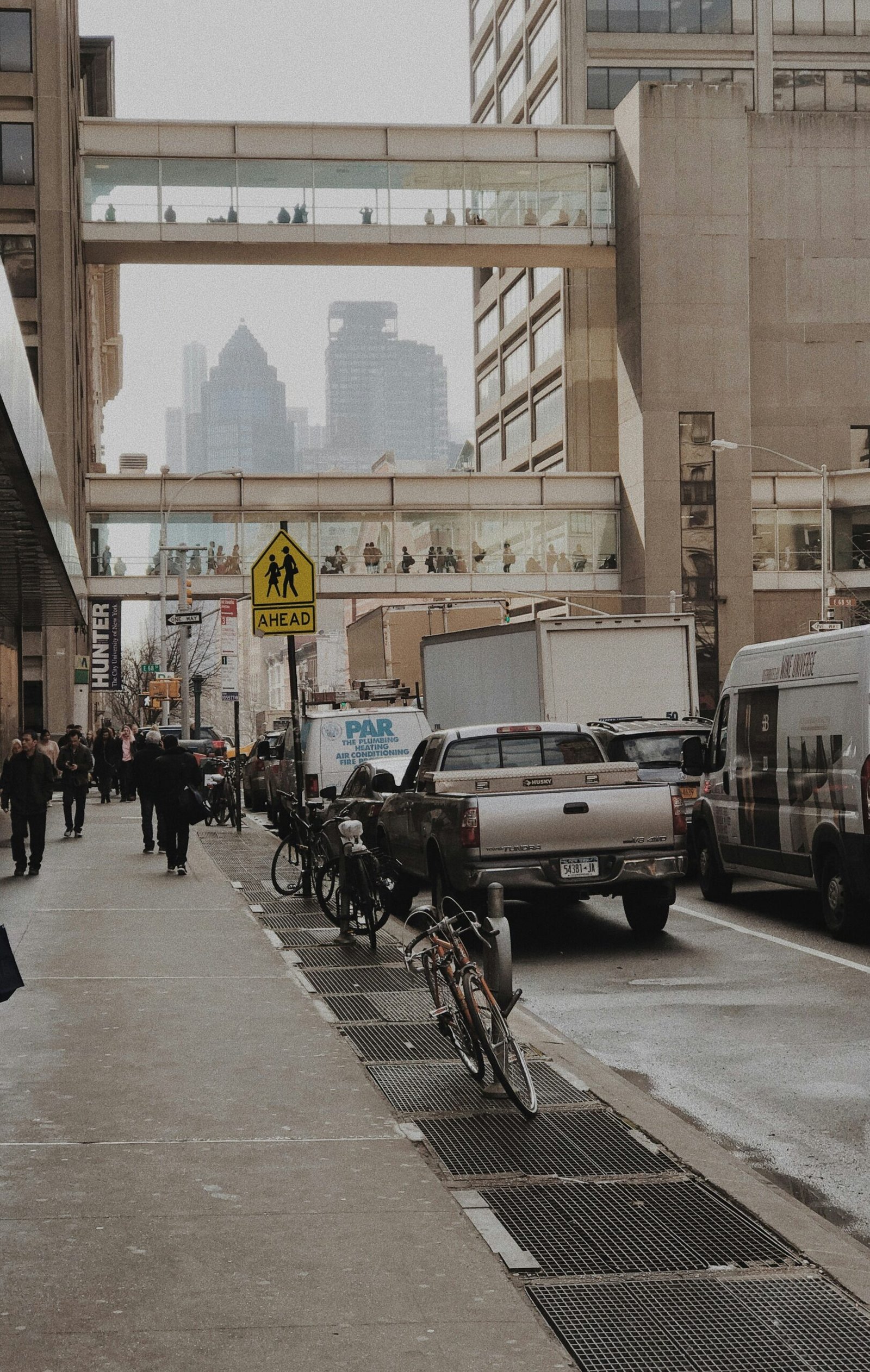 group of people walking beside vehicles near building during daytime