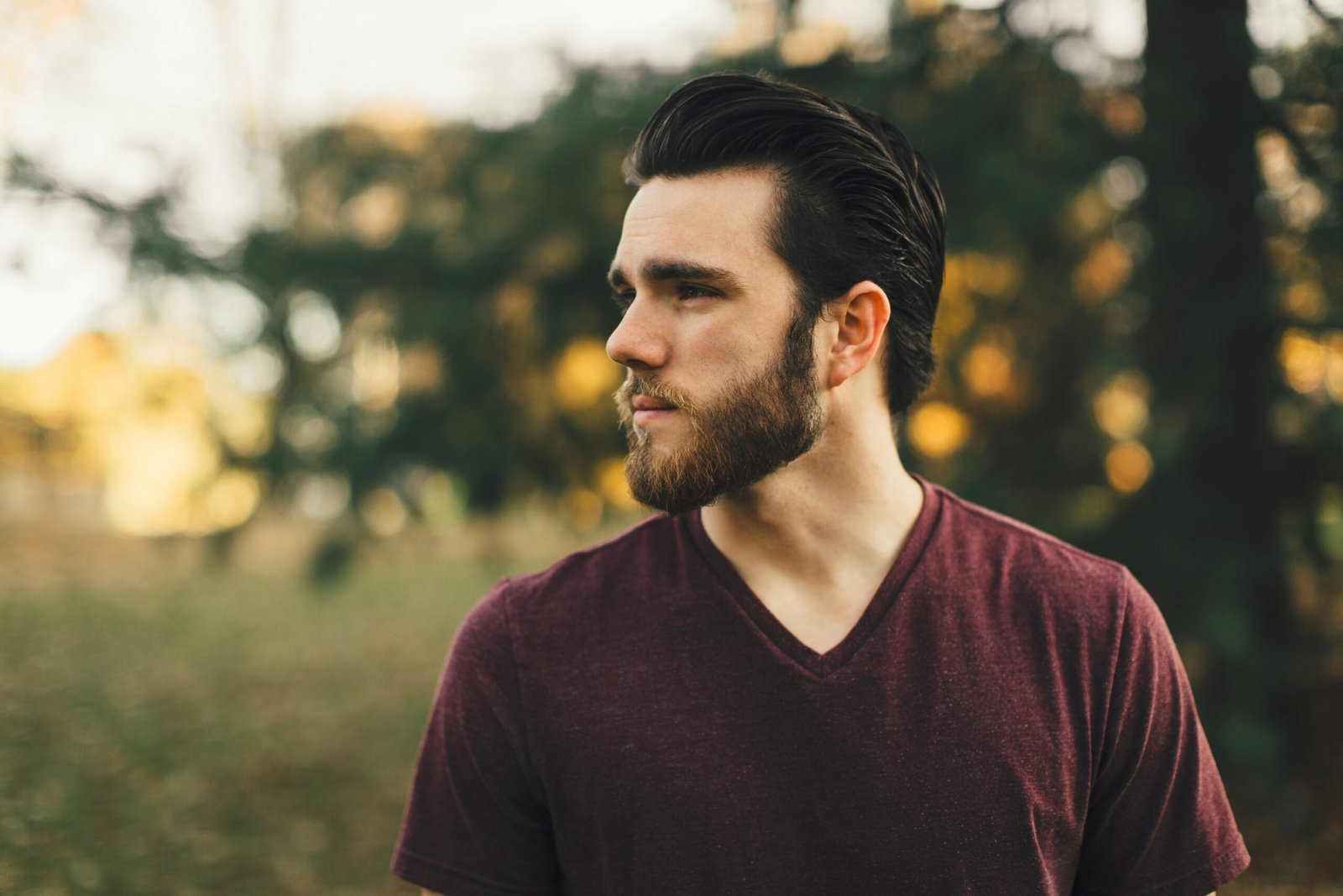 man wearing maroon V-neck t-shirt in forest