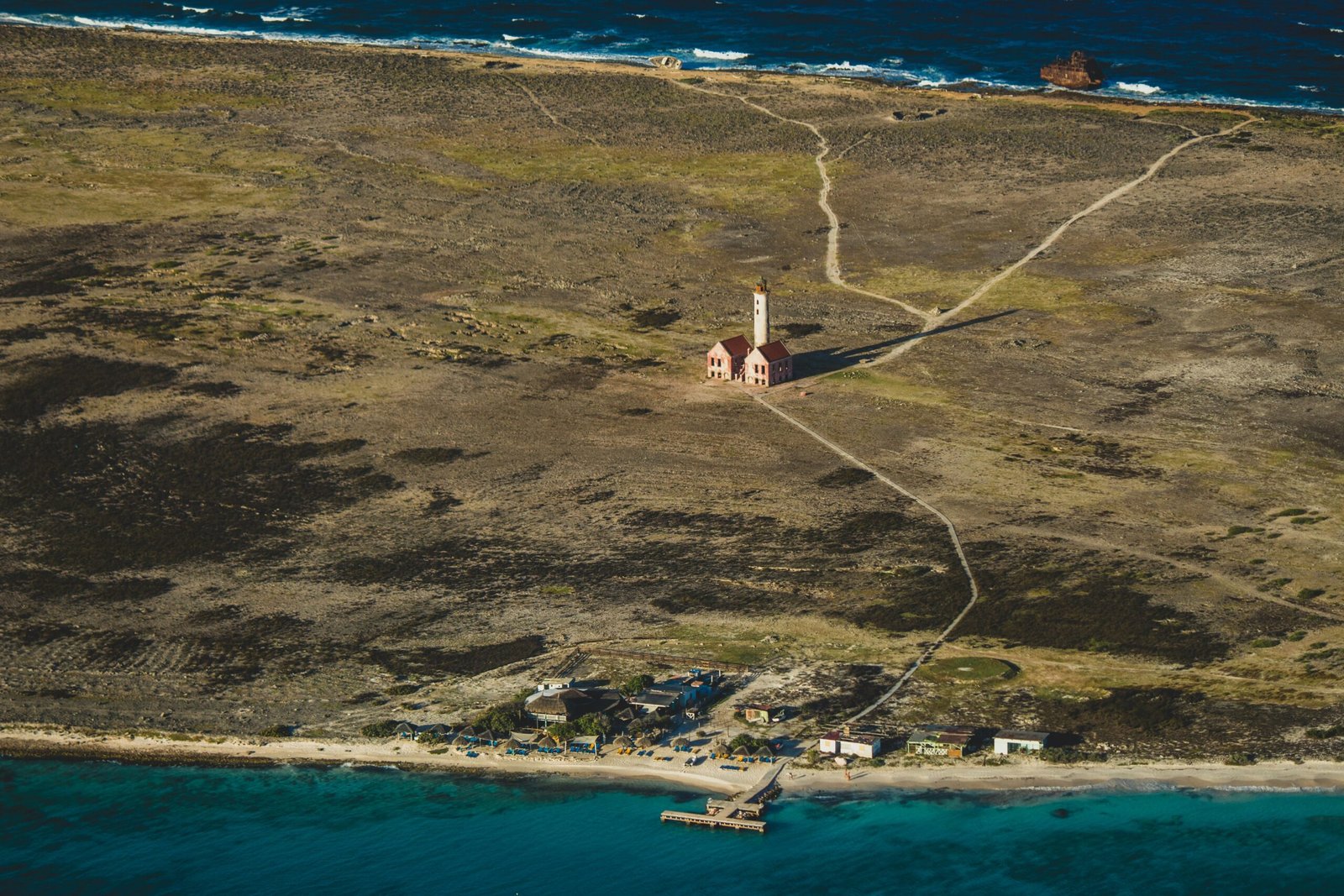 aerial photography of houses on green field near body of water