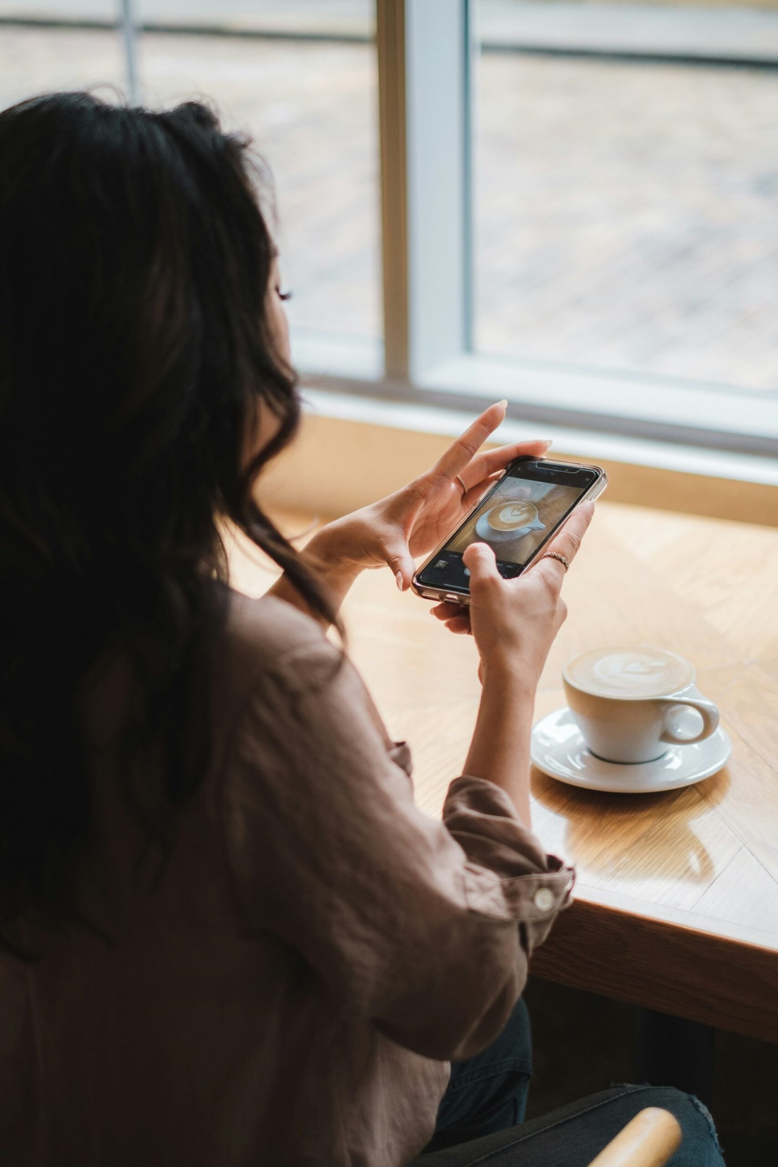 woman in white dress holding black smartphone